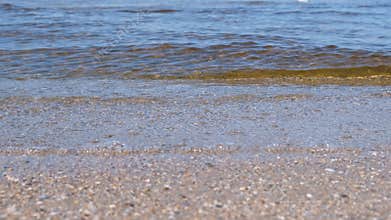 Sand beach with small waves. Beautiful seascape.