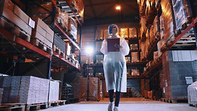 Candy factory. Controller checking factory storage room.