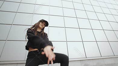 Woman dancer performs modern hip-hop dance, contemporary freestyle in the street, urban environment