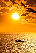 Seascape with boat at sunset