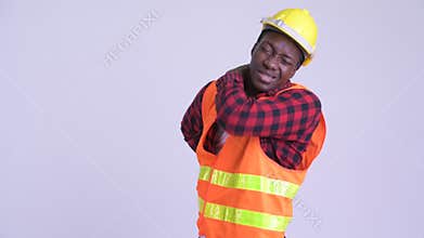 Young stressed African man construction worker having back pain