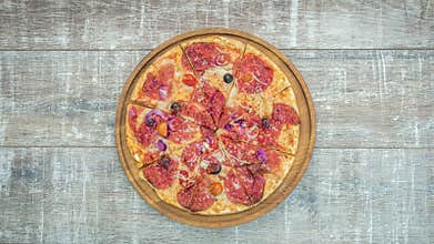 Stop motion of appearance of fresh pizza on a wooden table. Top view, 4K animation