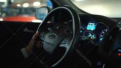 Man driving in innovative automated car using self-parking autopilot for parking on street