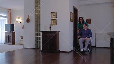 Care worker with young man in wheelchair at home