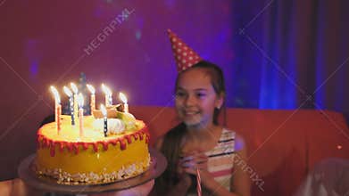 Mother carries the delicious cake with burning multicolored candles