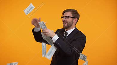 Wealthy businessman throwing money in air, received funding for start up, winner