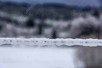 Barbed wire covered by thick snow