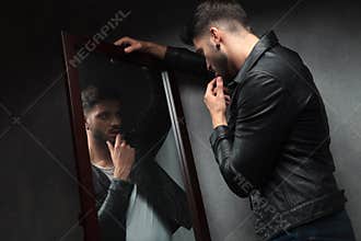 Narcissist young man admiring himself in the mirror