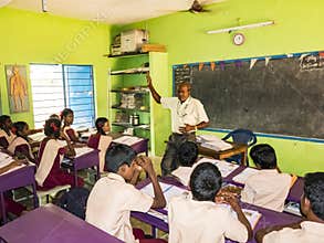 Group of children friends classmates studying with book sitting on chairs indoors at the school. School kids enjoying friendship