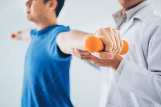 Physiotherapist man giving exercise with dumbbell treatment About Arm and Shoulder of athlete male patient Physical therapy
