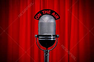 Microphone on stage with spotlight on red curtain