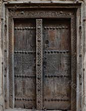 Ancient door carved with engravings of an ancient mud house in Oman