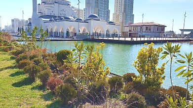 White mosque in a beautiful lake and green plants and trees