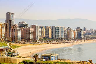 Downtown buildings and towers with road, sandy beach and sea in the foreground, Beirut, Lebanon