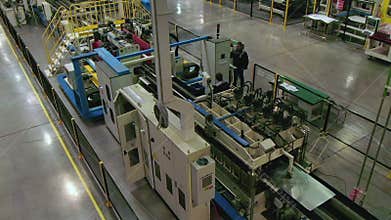 Man controls production line transporting metal at plant