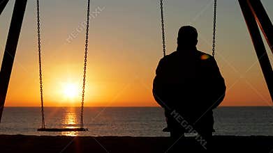 Man alone contemplating sunset on the beach