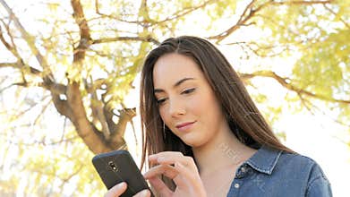 Serious woman using smart phone in a park