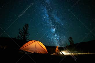 Tourist near his camp tent at night.