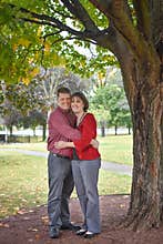 Married Couple Under Tree Hugging Each Other