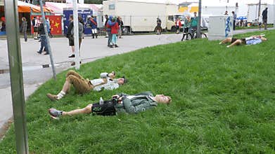 Drunk men lie on the lawn near the statue of Bavaria at the Oktoberfest festival. Bavaria, Germany