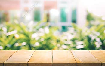 Wood table top on blur of window with garden flower background