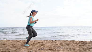 Athletic woman running along the beach. Video at different speeds - quick, normal and slow