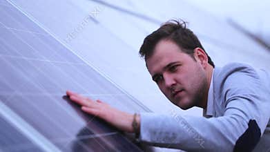 Solar panels, the man looks at the surface of the batteries.