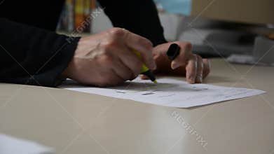 Male hands highlighting text on document