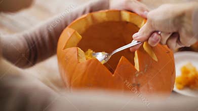 Close up of woman carving halloween pumpkin
