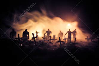 Silhouette of zombies walking over cemetery in night. Horror Halloween concept of group of zombies at night