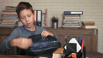 Boy packing his backpack for school
