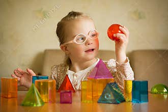 Girl with Down syndrome playing with geometrical shapes