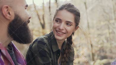 Beautiful young girl laughing happily, to a beautiful guy wearing a beard. Autumn Walking Youth