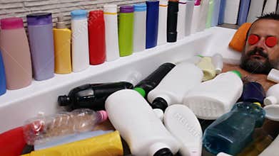 Plastic spa - man relaxing in bathtub covered with plastic waste