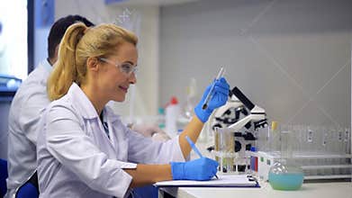 Friendly scientist consulting with colleague while examining plant specimen