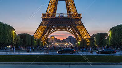 Eiffel Tower day to night timelapse and people sitting on the grass in the evening in Paris, France
