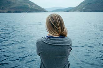 Back view of woman thinking alone and watching the sea with the