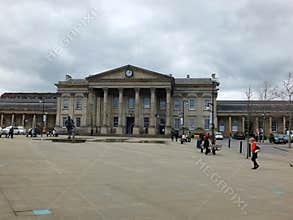 Pedestrians in St Georges Square walk past the historic railway station building.