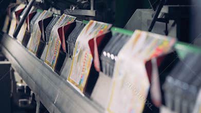 A row of colourful printed cards moving along the conveyor belt