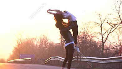 A pair of ballet dancers on the road dance, a man performs support in the air