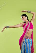 Beautiful indian young brunette woman dancing