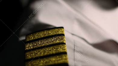 Aircrew captain at work, closeup of pilot's shirt epaulets, career in aviation