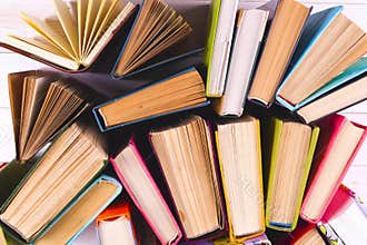 Open book, hardback books on bright colorful background.