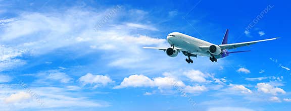 Passenger airplane flying above clouds. View from the window plane to amazing sky with beautiful clouds.