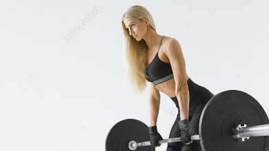 Fit young woman lifting barbell