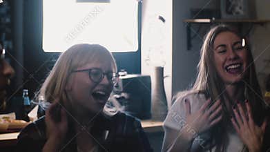 Happy young people dance at party with confetti. Slow motion close-up. Multi-ethnic group joyful celebration. Emotion.