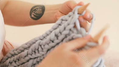 Knitting close up. Womans hipsters hands with cool tattoo .Video footage