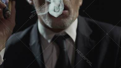 Arrogant gangster smoking expensive Cuban cigar, dangerous mafia, slow-motion