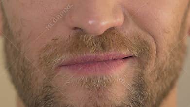 Close up of man's face smirking into camera, arrogant male, body language