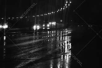 Rain at night on the road with street lights in the dark street